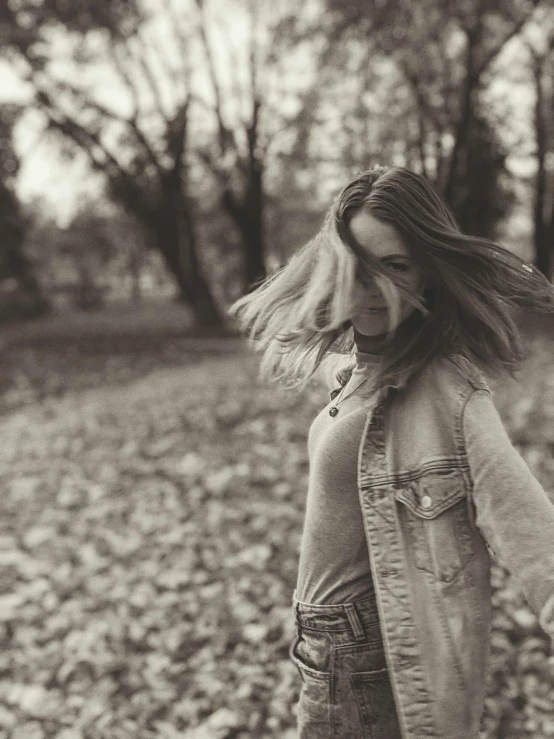 a woman walking through a forest holding onto her cellphone