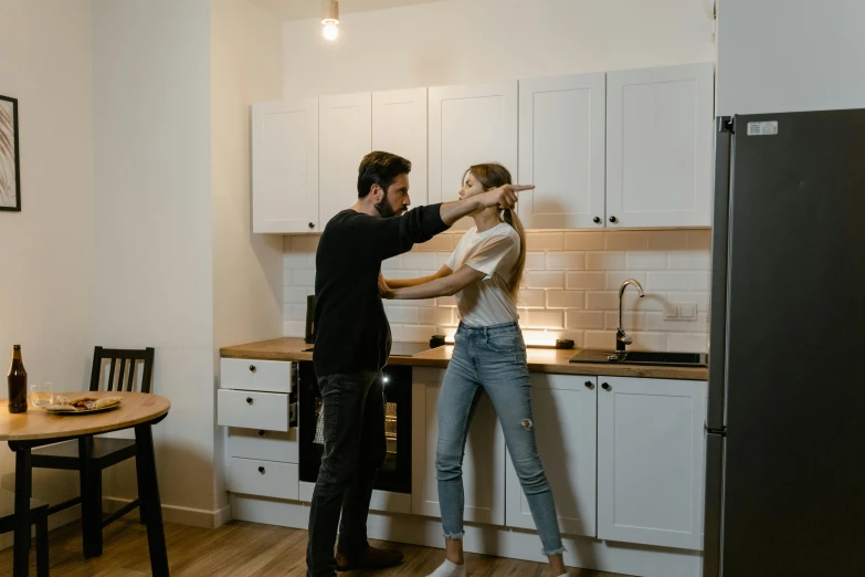 two people are taking a picture in the kitchen