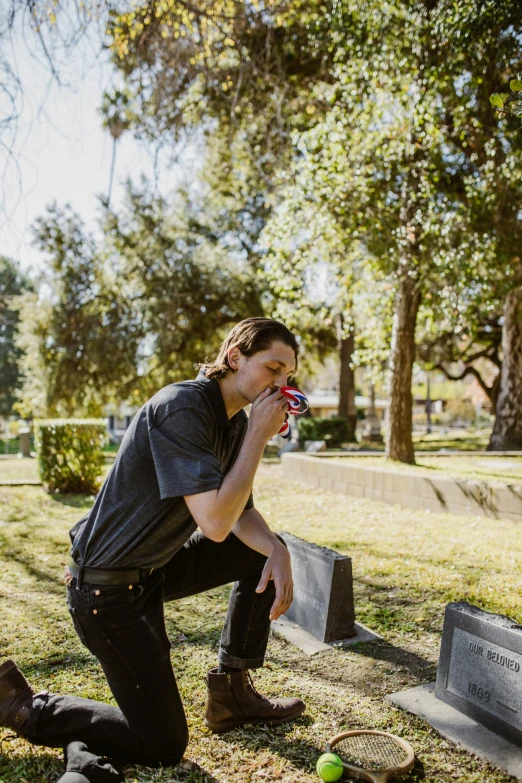 a man sitting on a bench in the grass by a dog