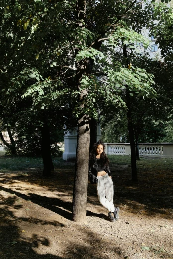 a woman sits on a tree trunk in a park