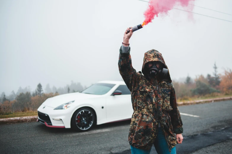a person in a hood jacket with a red smoke lighter
