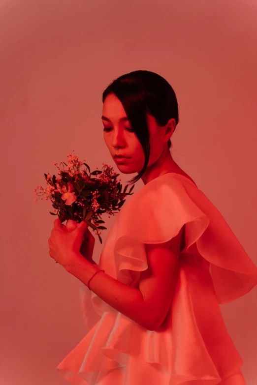 woman in white dress holding small flowers in her hand