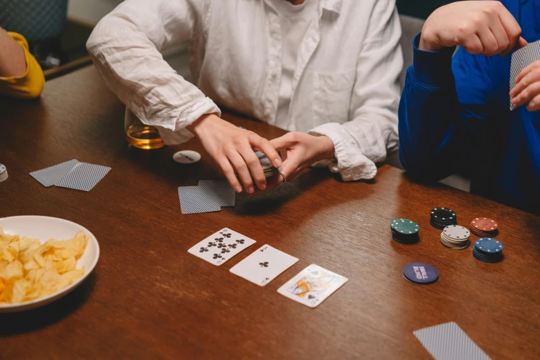 a man sits at a table in front of the camera and his chips are being played on