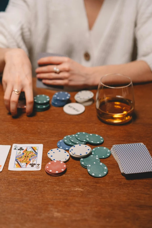 a person sitting down at a table with cards and chips