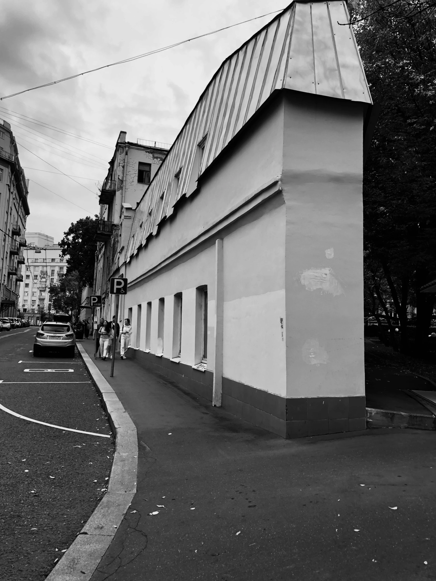 a black and white image of a house on the side of the road