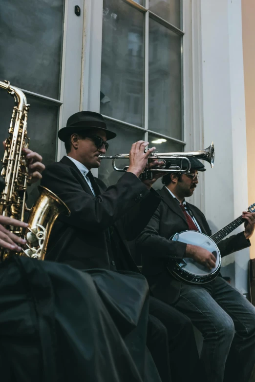 some people in suits playing instruments near a window