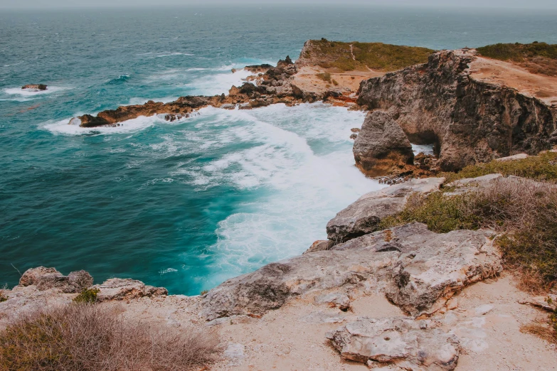 a picture of a water front with cliffs and waves crashing