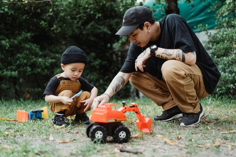 a father and son playing with toys in the park