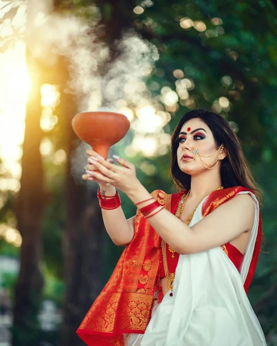 woman in a red and white saree tossing an orange frisbee