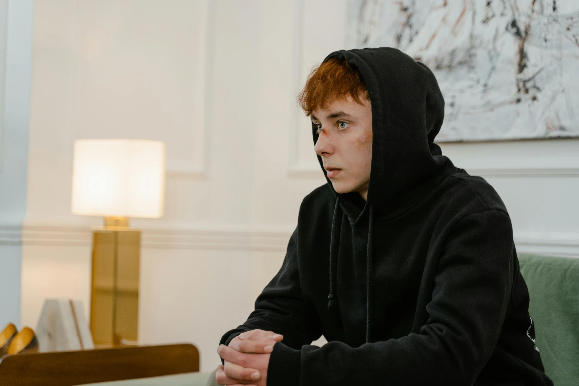a boy in a hoodie is looking at the camera