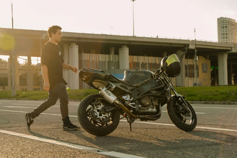 a man is walking towards a motorcycle that is parked in a parking lot