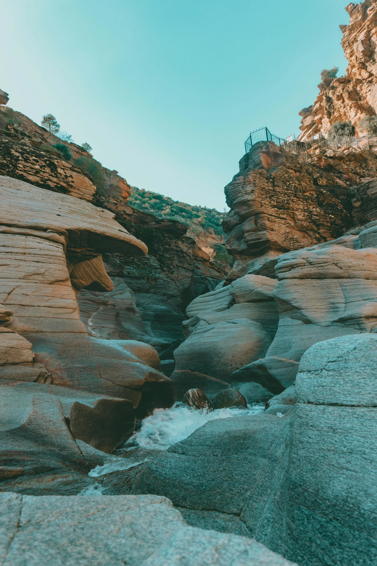 a rocky cliff is shown with some water flowing