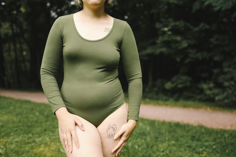 a woman with tattoos in a field of grass