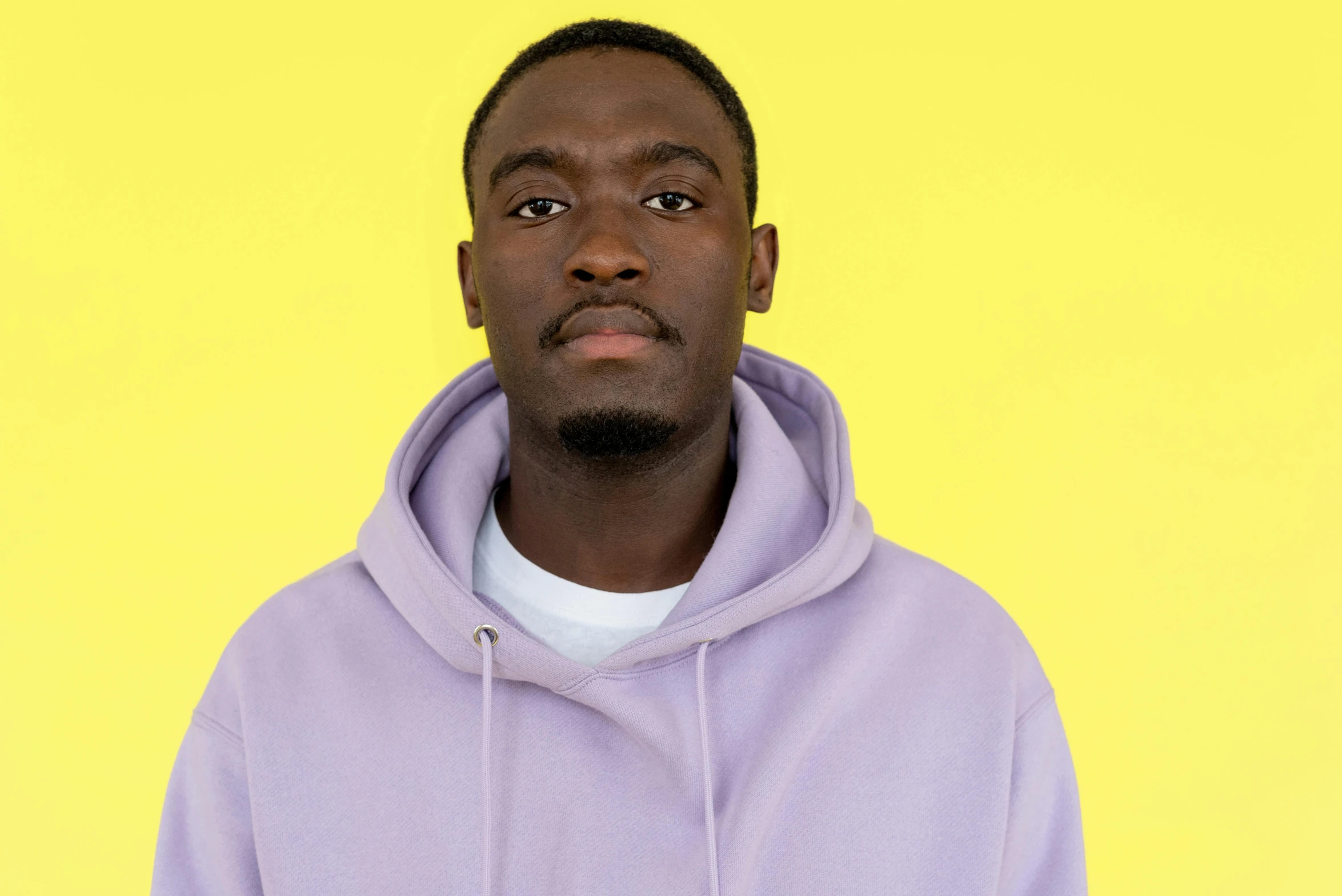 a man with a purple hoodie on poses for a picture