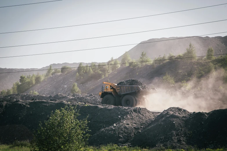 a large dump truck traveling through a gravel road