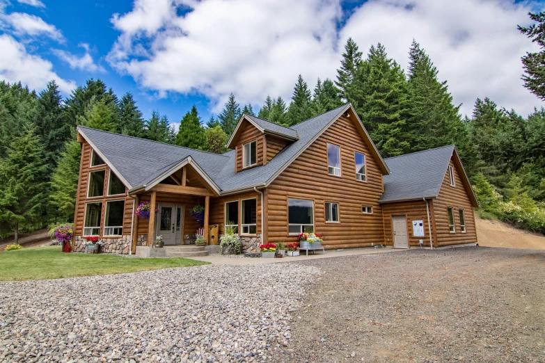 a house in the woods with a gravel driveway