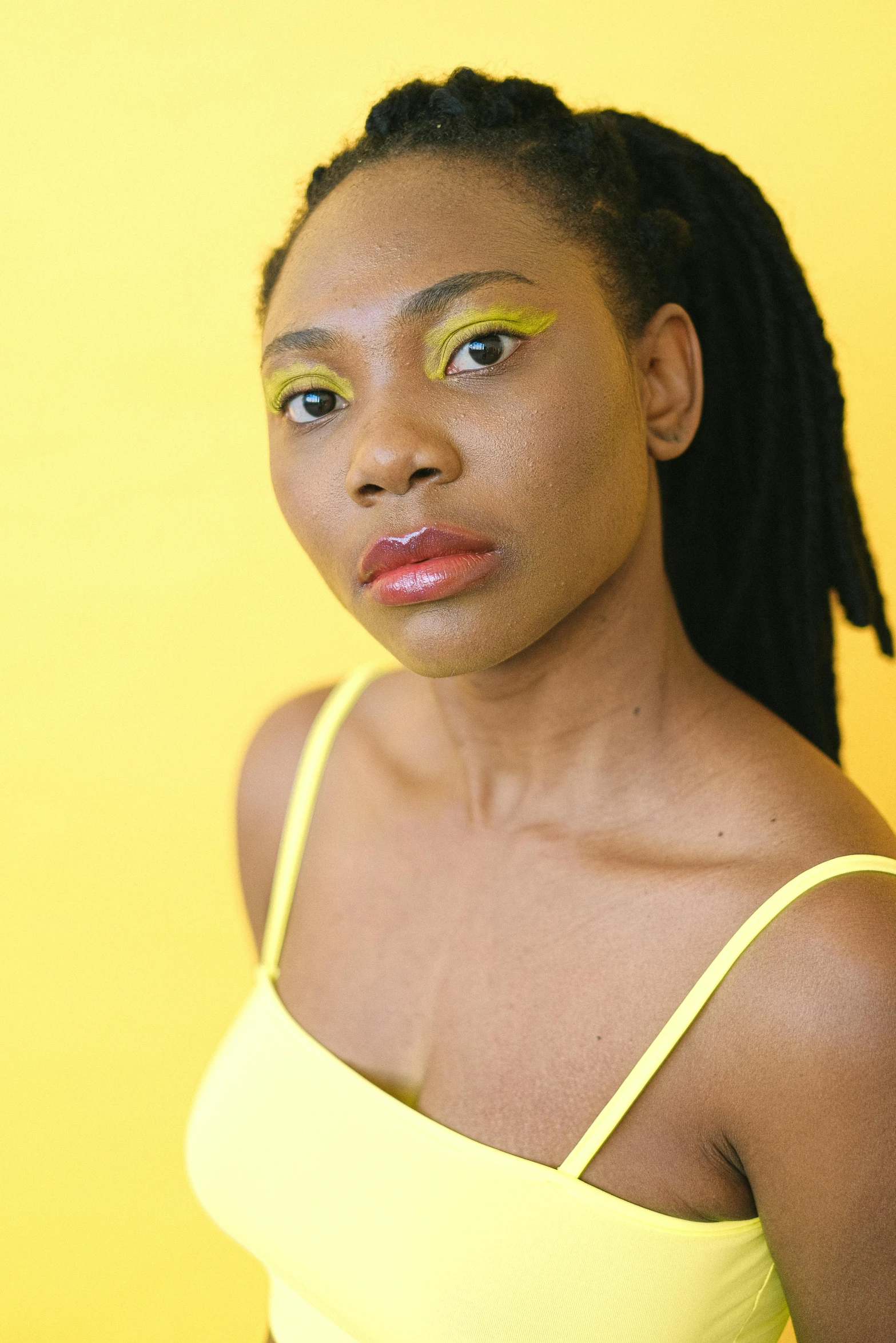 a woman in a yellow top is posing