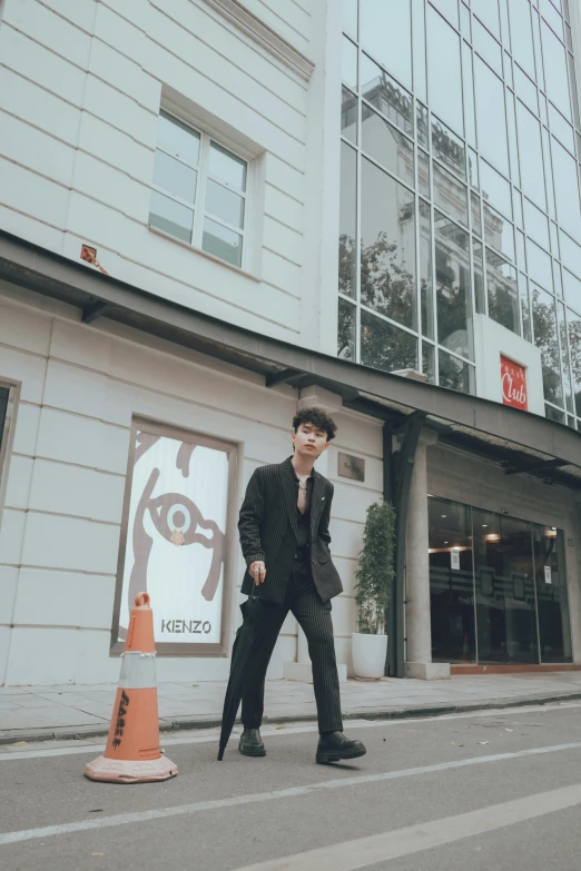 a man walking across a street past a tall building