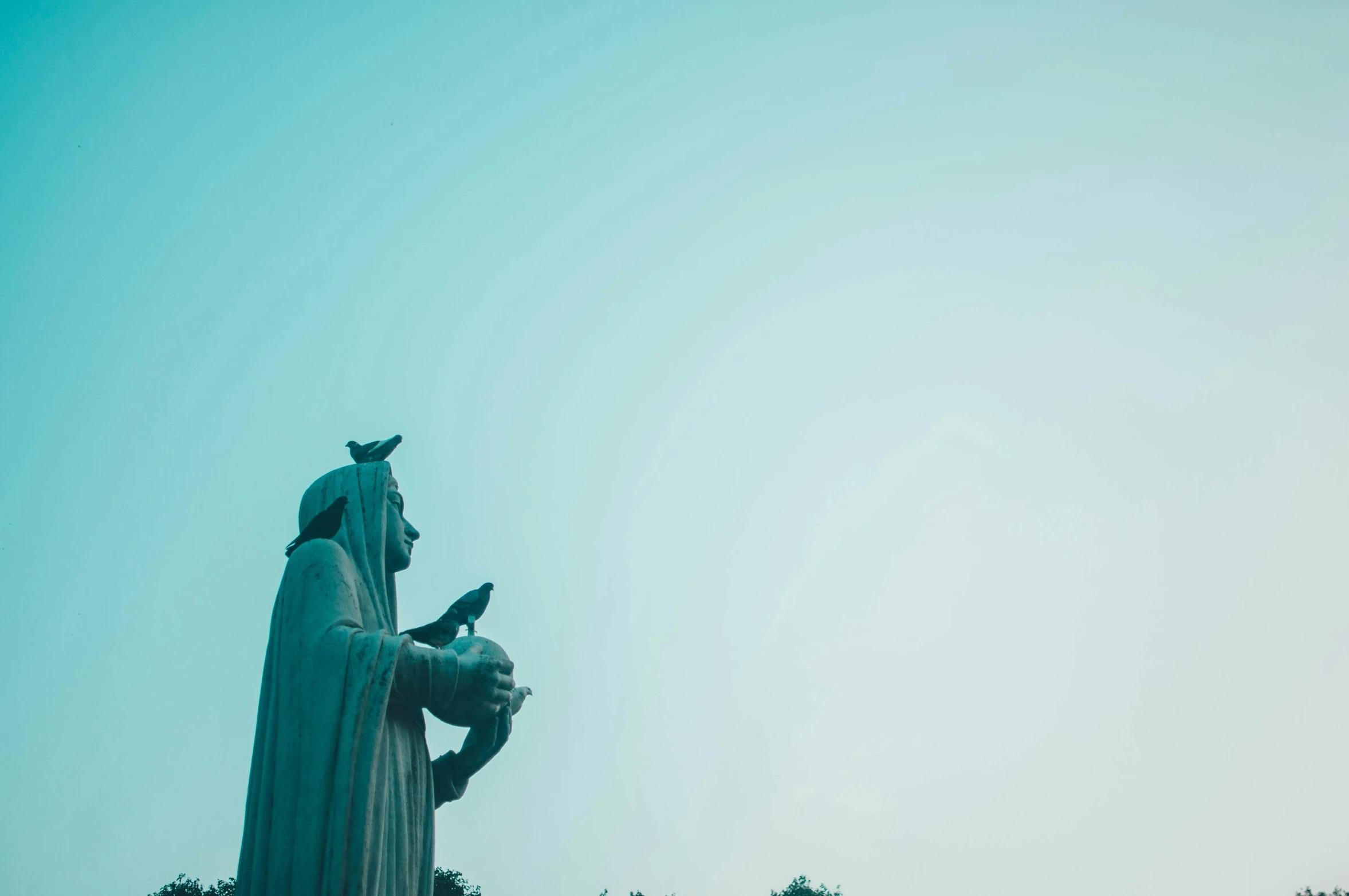 a statue stands tall next to a blue sky