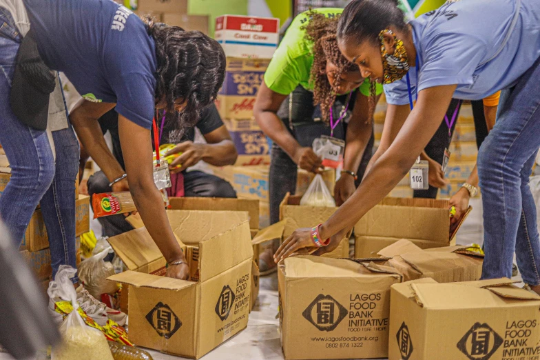 several people are trying to put food in boxes