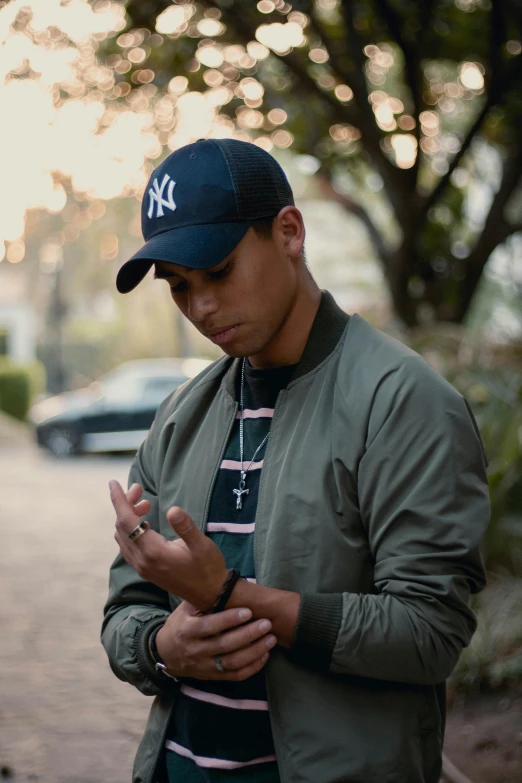 a man wearing a yankees baseball hat standing on the street