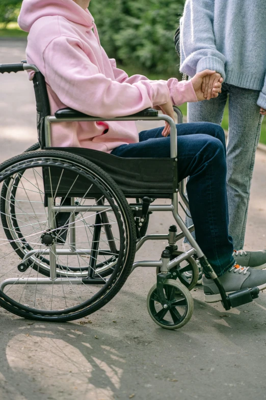 a woman hing a wheelchair holding a hand