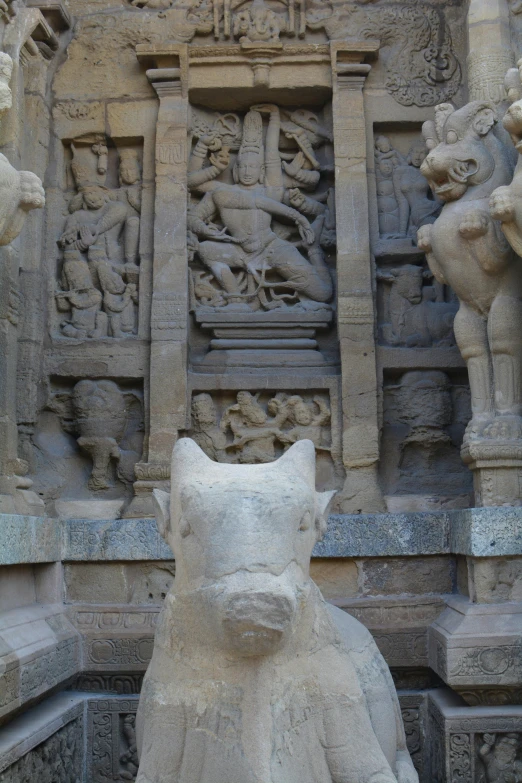 a bear made out of stone sitting on some steps