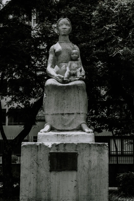 statue in a park that includes an old woman