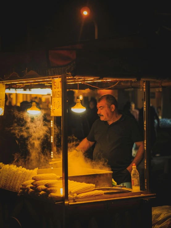 a man working in the smoke of a cart of food