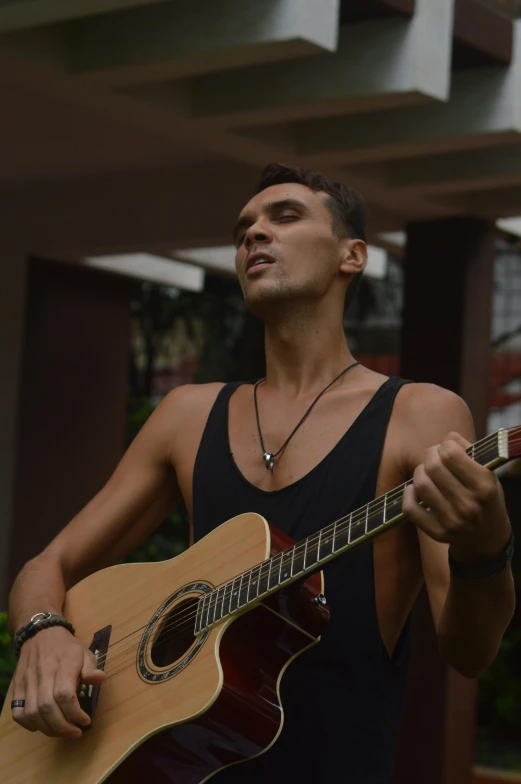 a man is holding a guitar outside