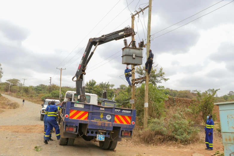 two men in work wear standing near a utility truck