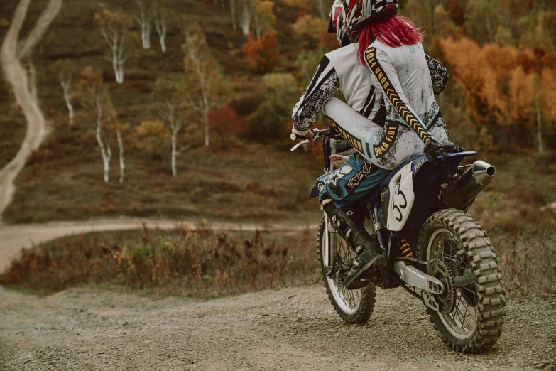 a person on a dirt bike wearing a full motorcycle outfit