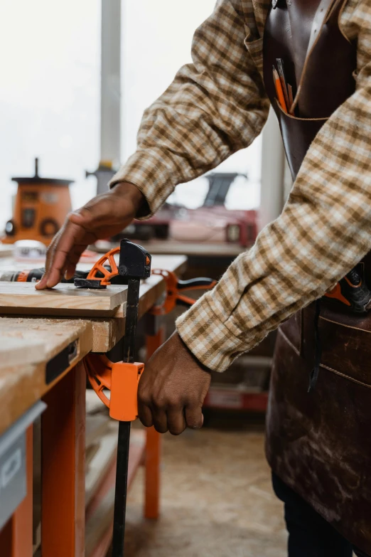 man  wood with a power saw and orange tool