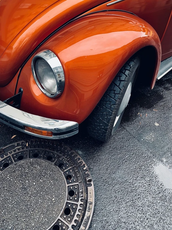 a classic orange car on display outside