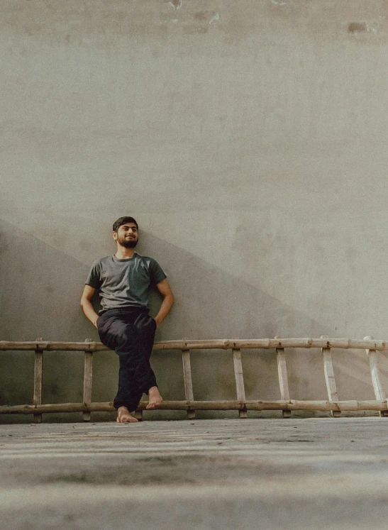 a man sitting in front of a concrete wall