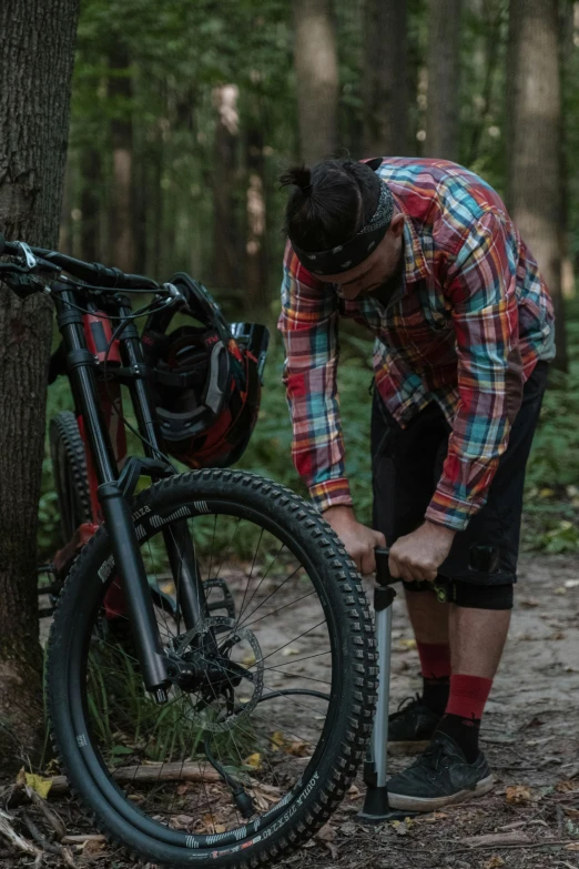 a guy putting together a bike in the woods