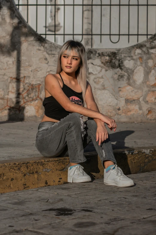 a woman sitting on the curb next to a building