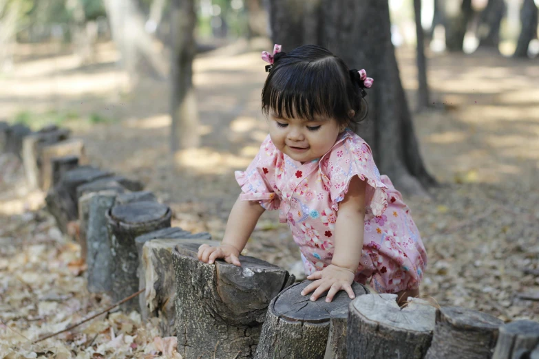 a  in pink shirt leaning over log