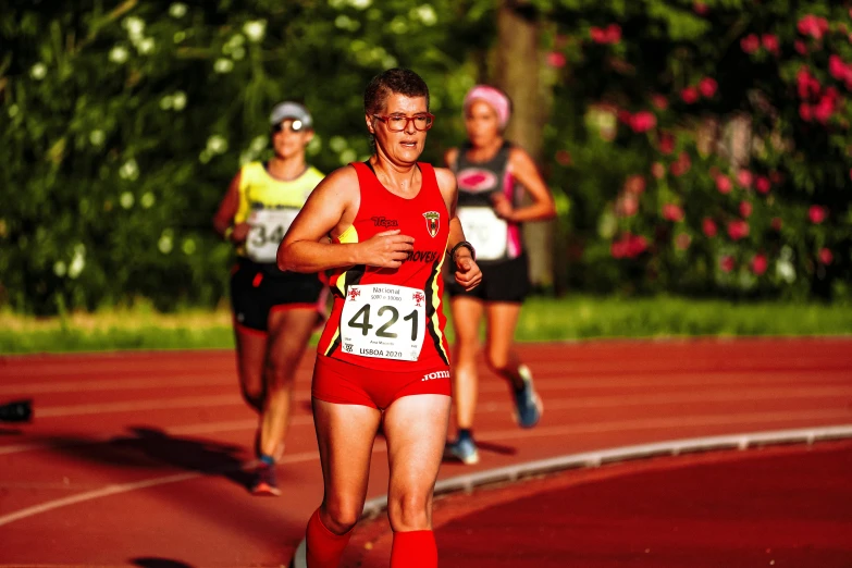 some people running on the track in a track suit