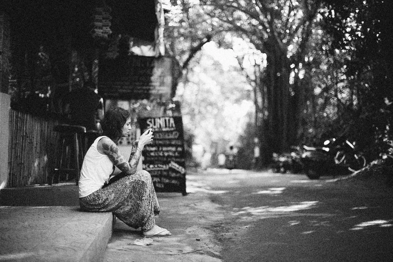 a woman sitting on a wall with her hands up while she is holding soing