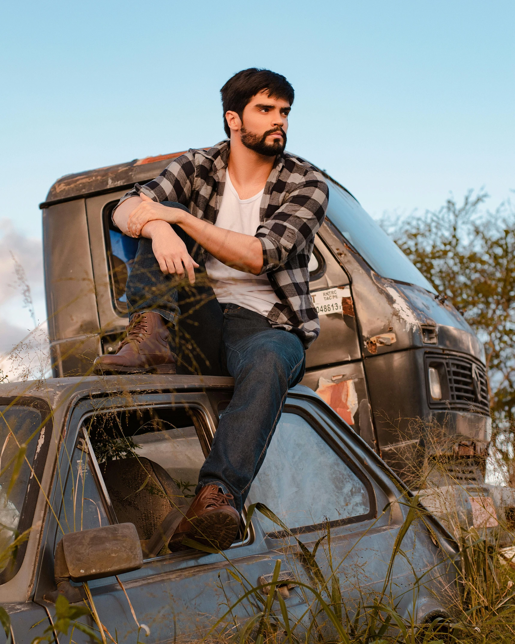 the man is sitting on top of an old car