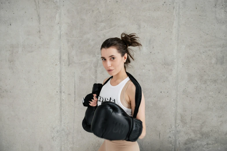 young female with large black boxing glove and shirt on