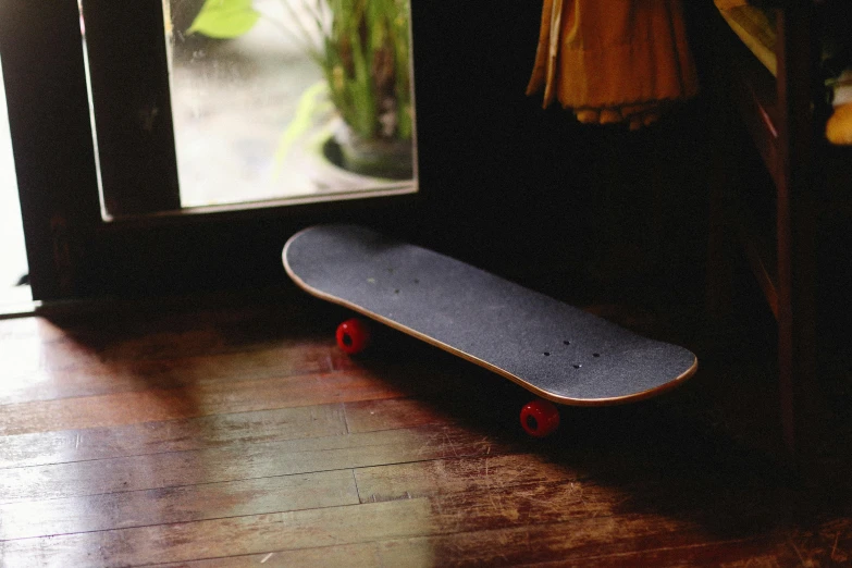 a skateboard is on the floor next to a window