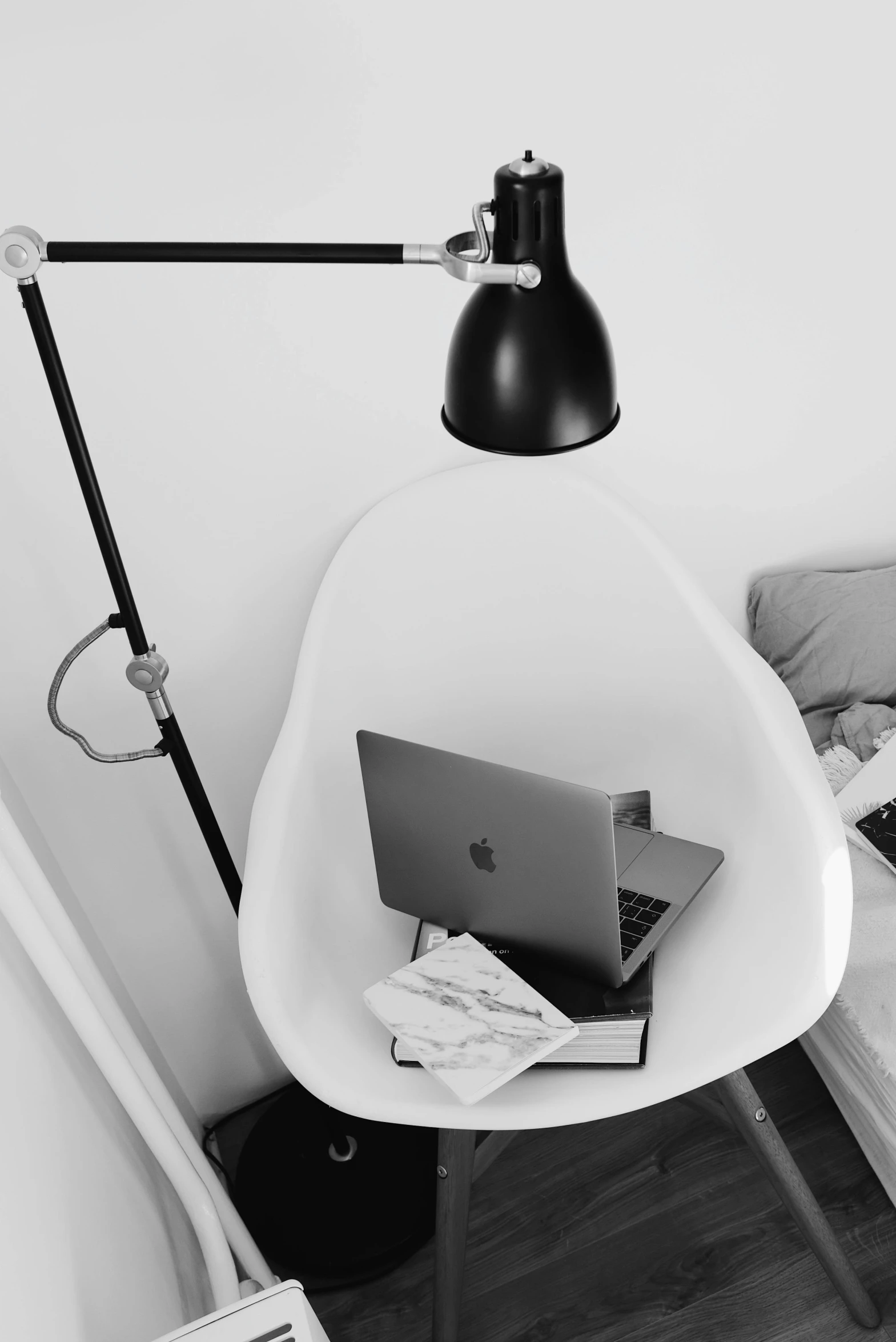 a desk with laptop and lamp in small room