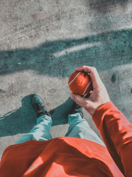 a person sitting holding an orange in their hand