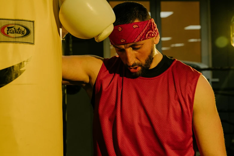 a man in red shirt standing next to a punching bag