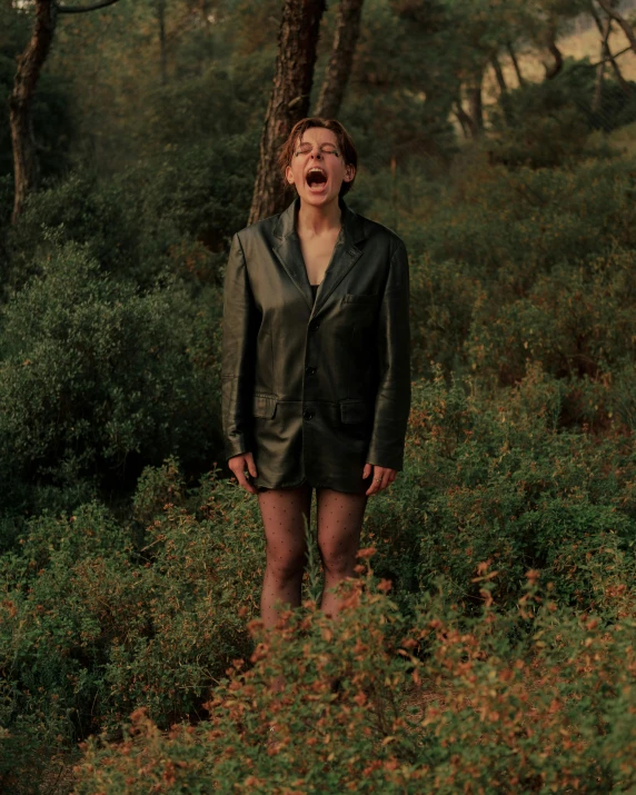 a woman stands on a path in a forest