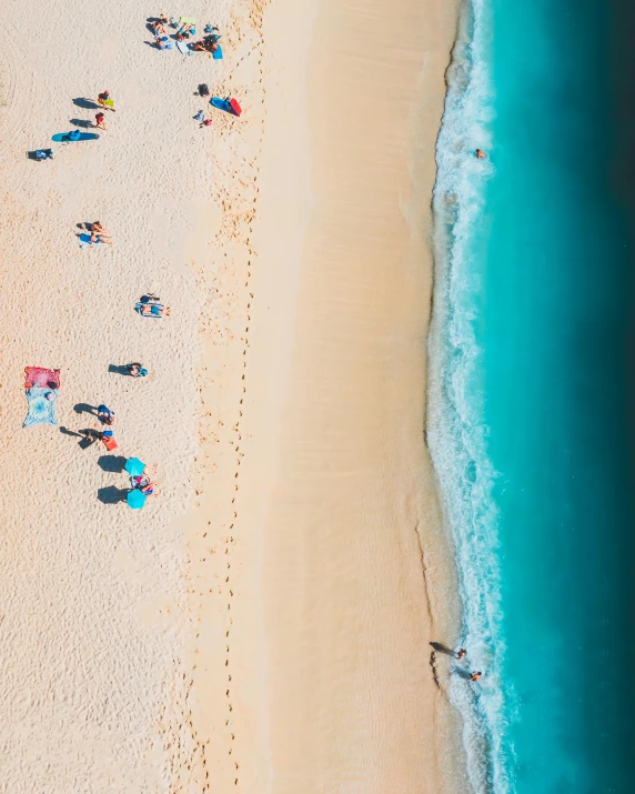 a group of people laying on a beach near the ocean