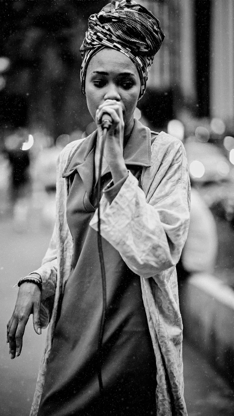 the woman is singing into her microphone on the street