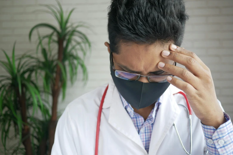 a doctor wearing sunglasses with the necktie undone